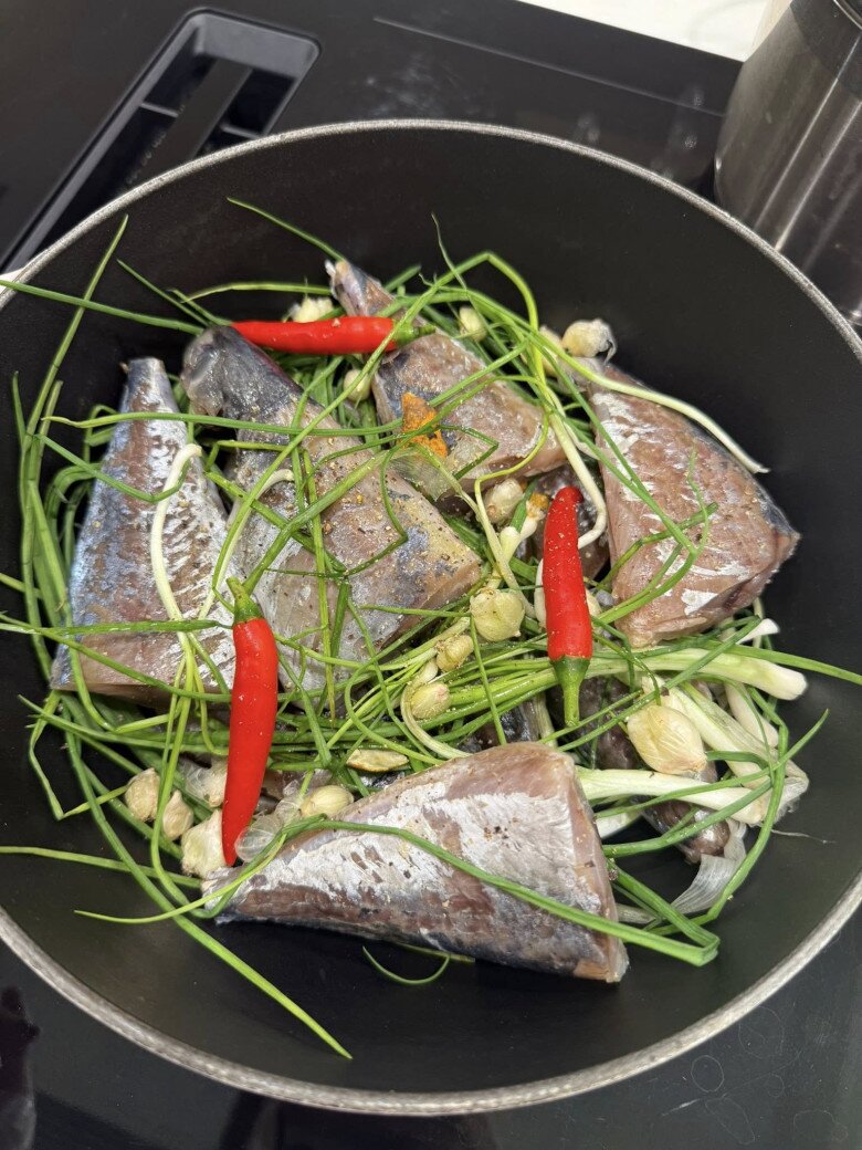 Nguyên liệu của cô gồm có: Cá mắm, hành tăm tươi, ớt, tiêu, mật mía, vỏ quýt hôi, nước chè xanh, rưới thêm 2 muỗng dầu ăn, cho hết vào nồi kho cho đến khi cạn.