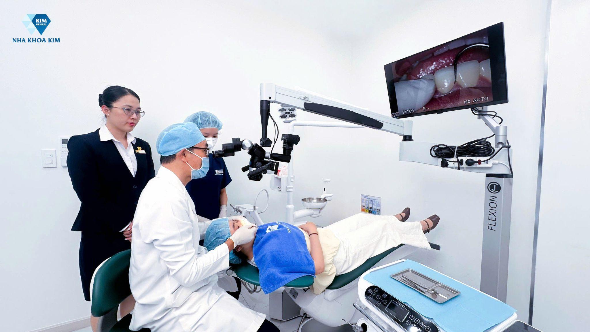 Bác sĩ đang thực hiện bọc răng sứ thẩm mỹ, kiểm soát đường hoàn tất bằng kính hiển vi nha khoa để đạt kết quả hoàn hảo