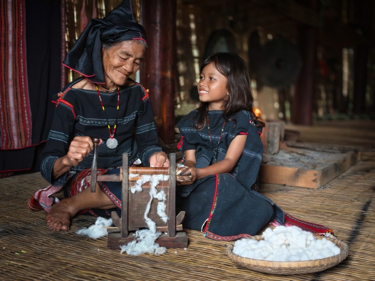 Hơi thở Bahnar trong ánh sáng đại ngàn 9 Người bà chỉ cho cô cháu nhỏ cách xử lý sợi bông. Ảnh: Ngô Trần Hải An.