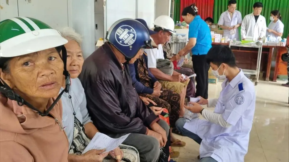 Nhân viên y tế rất tận tình khi thăm hỏi, phát thuốc cho người dân vùng lũ. Ảnh: T.T người dân 002.jpg