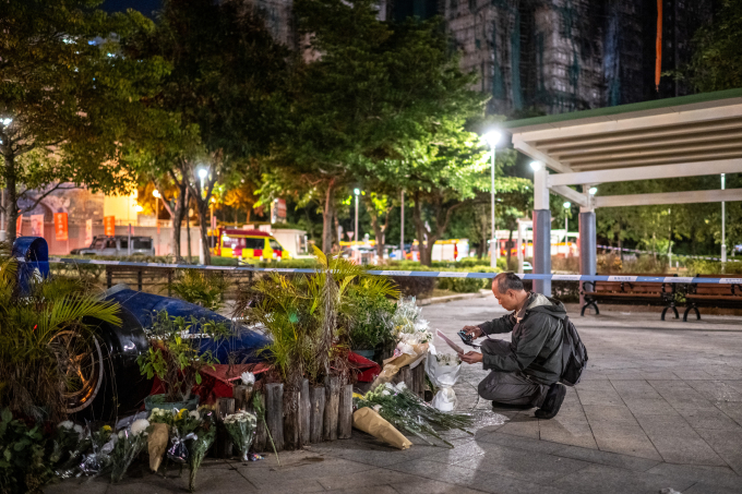 Khu vực đặt hoa tưởng niệm các nạn nhân trong vụ cháy chung cư Wang Fuk Court ở Hong Kong tối 28/11. Ảnh: AFP