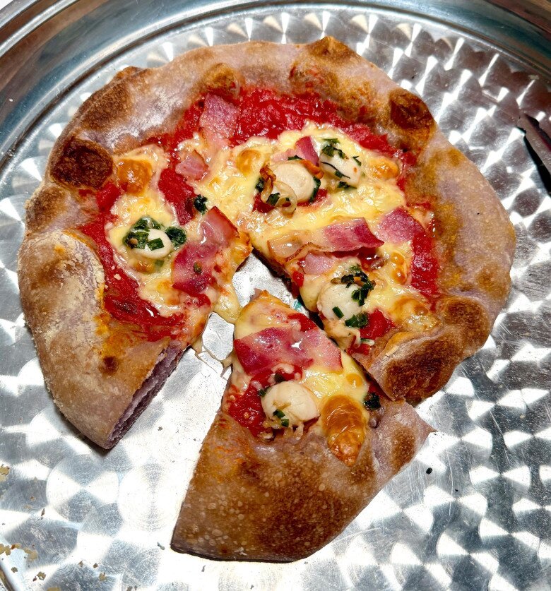 Ông xã cũng chiều chuộng sở thích của Khởi My khi cô muốn tập tành làm bánh. Chiếc pizza Napolitana thủ công với viền bánh nở đều, topping gồm phô mai, thịt xông khói, hải sản, sốt cà và rau thơm. Đây là kết quả sau nhiều lần luyện tập. Khởi My hóm hỉnh: “Nay mình tới pizza Napolitana. Sau bao nhiêu cái clip Kéo Zìn (Kelvin) lưu lại cách nặn bánh và các thành viên gia đình thử độc gần chục cái pizza do My nặn, thì nay cũng thành công rồi”.