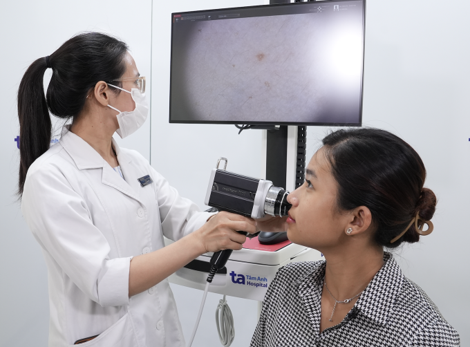 Bác sĩ khoa Da liễu soi da cho một người bệnh sau điều trị mụn trứng cá. Ảnh minh họa: Bệnh viện Đa khoa Tâm Anh