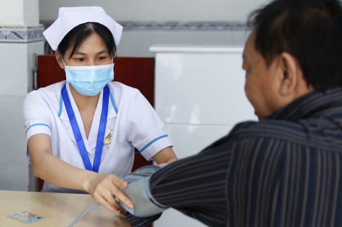 Nhân viên y tế đo huyết áp cho người dân. Ảnh: Quỳnh Trần
