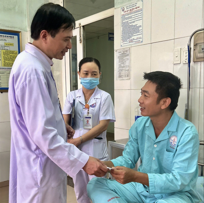 Ông Phan Xuân Nam, Giám đốc Bệnh viện Đa khoa tỉnh Quảng Trị thăm hỏi và giải thích cho bệnh nhân về tổn thương vết mổ sau phẫu thuật nội soi. Ảnh: Bệnh viện cung cấp