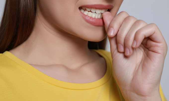 Cắn móng tay không chỉ làm mất thẩm mỹ, mà còn tiềm ẩn nhiều nguy cơ đối với sức khỏe. Ảnh tạo bởi AI