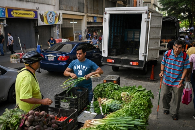 Người dân Venezuela hỏi mua rau tại một quầy bán rau dạo ở khu dân cư La Candelaria tại Caracas ngày 13/11. Ảnh: AFP