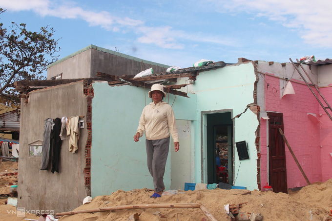 Chị Nguyễn Thị Điệp trước ngôi nhà nứt toác, hư hỏng sau bão, chiều 12/11. Ảnh: Trần Hóa