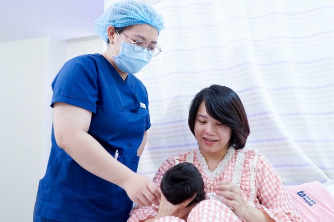 Điều dưỡng hướng dẫn chị Hoa cách chăm sóc bé sinh non trước khi xuất viện. Ảnh: Ngọc Châu