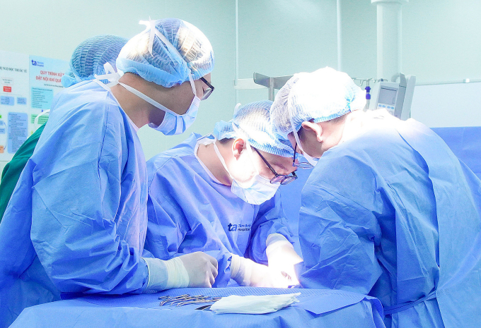 Bác sĩ Trần Huy Phước (thứ hai từ phải sang) cùng êkíp phẫu thuật đặt tinh hoàn nhân tạo cho người bệnh. Ảnh: Duy Dương