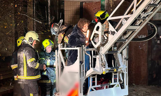 Lính cứu hỏa sơ tán người dân sao đòn tập kích của Nga vào thành phố Dnipro hôm 8/11. Ảnh: AP