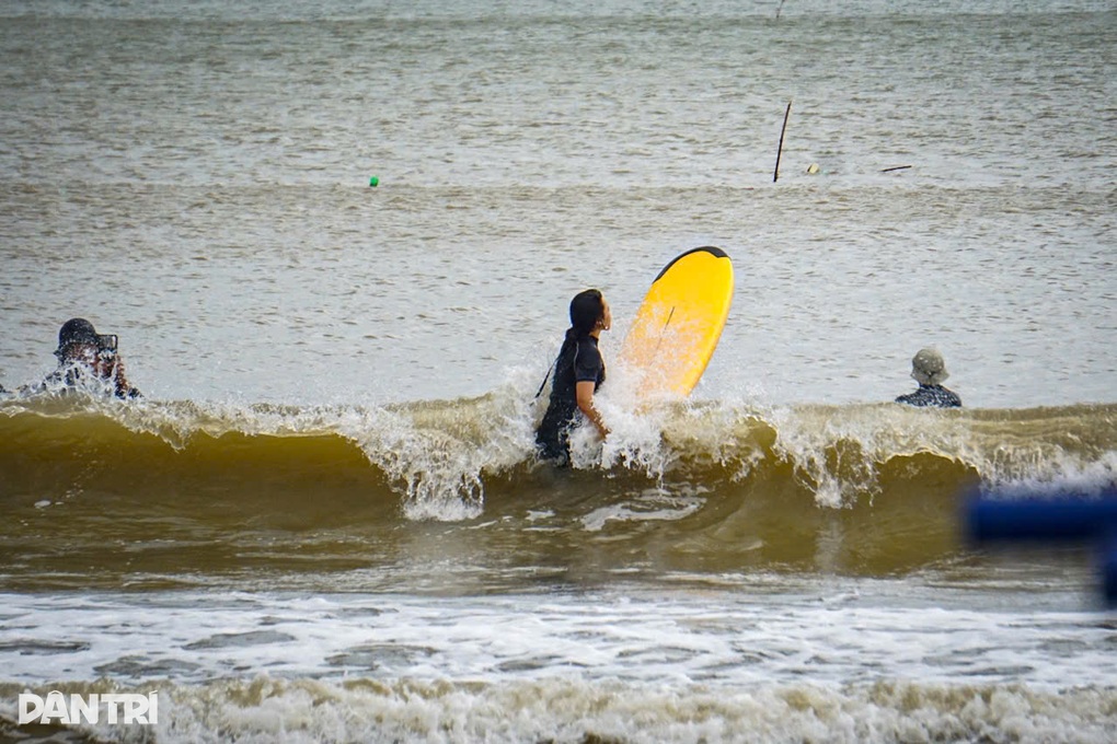 Du khách ra biển lướt sóng trước giờ bão Kalmaegi áp sát - 1