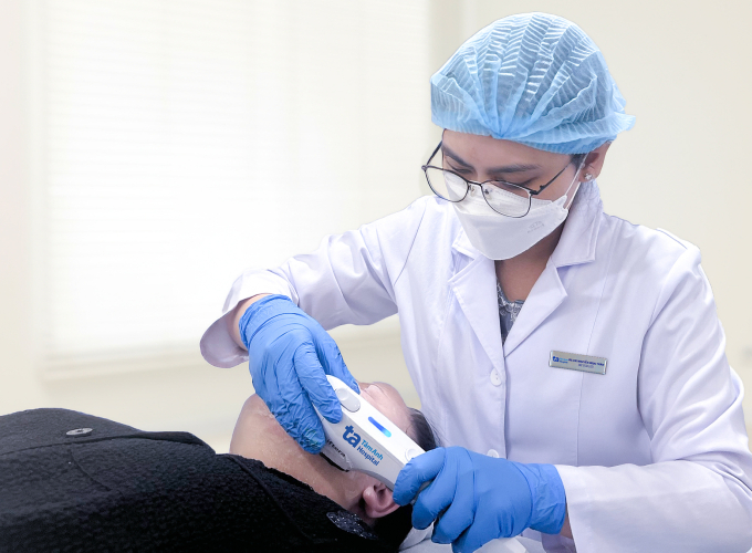 Bác sĩ sử dụng sóng siêu âm hội tụ để săn chắc vùng cằm cho chị Thu. Ảnh: Bệnh viện Đa khoa Tâm Anh