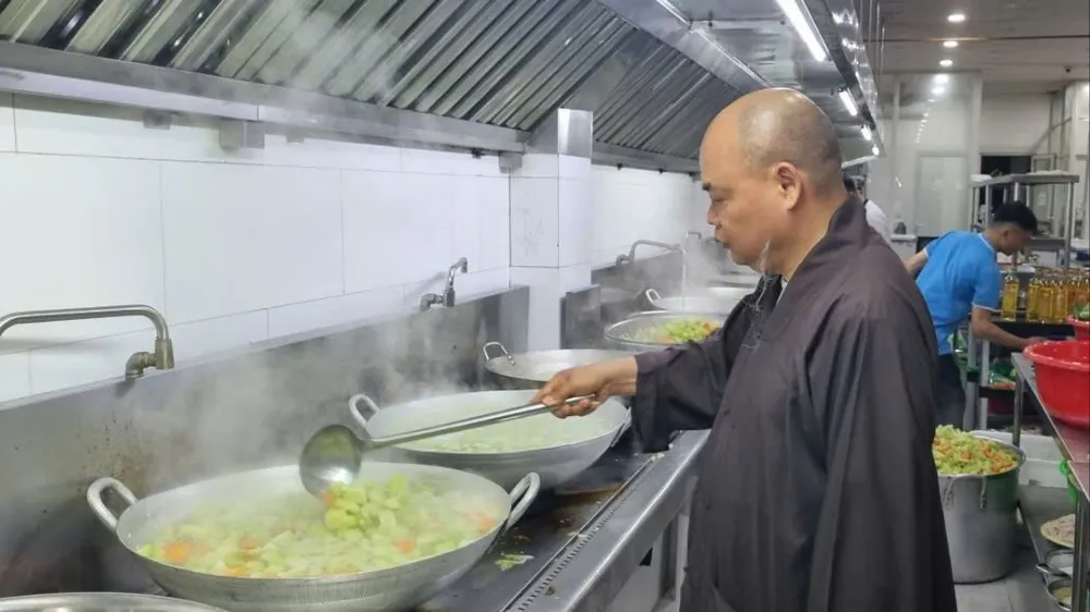 Thượng tọa Thích Thanh Phong vào bếp, chế biến và nấu đồ ăn giúp bà con. Ảnh: T.T người dân 2.jpg