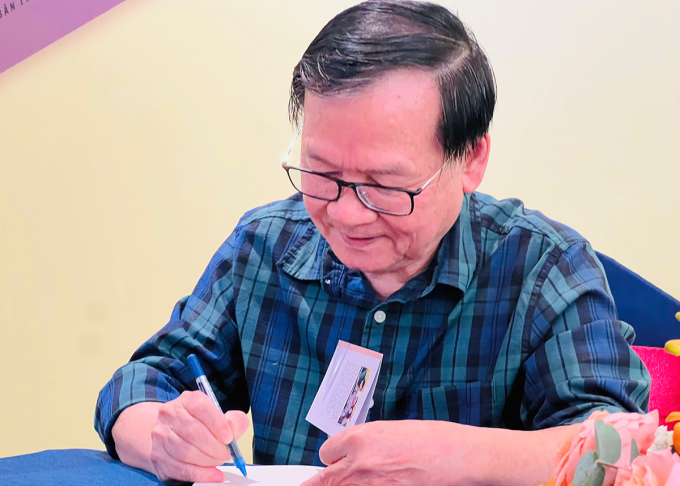 Nhà văn Nguyễn Nhật Ánh ký tặng sách mới tại họp báo. Ảnh: Hoàng Dung