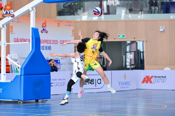 Đội trưởng Vũ Dương Bảo Thy (số 98, trắng) tranh chấp bóng với Nguyễn Vũ Minh Hà trong trận bán kết Giải bóng rổ Trẻ VnExpress, tại Cung Thiếu nhi Hà Nội cơ sở 2 hôm 30/11. Ảnh: VYB