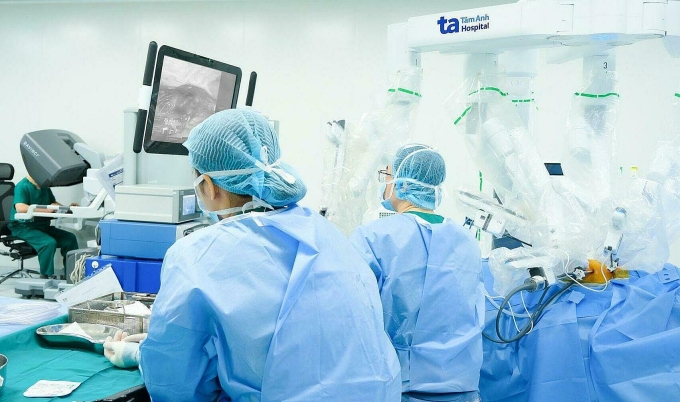 Bác sĩ điều khiển cánh tay robot loại bỏ khối u tuyến ức. Ảnh: Minh Huyền