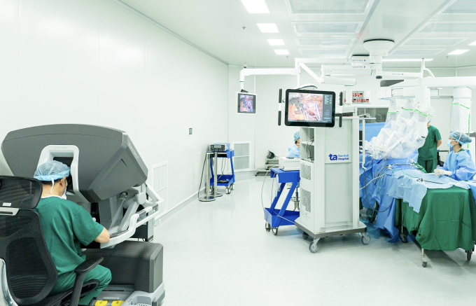 PGS Chuyên (trái) ngồi buồng điều khiển robot Da Vinci Xi thực hiện phẫu thuật ung thư tiết niệu. Ảnh: Bệnh viện Đa khoa Tâm Anh
