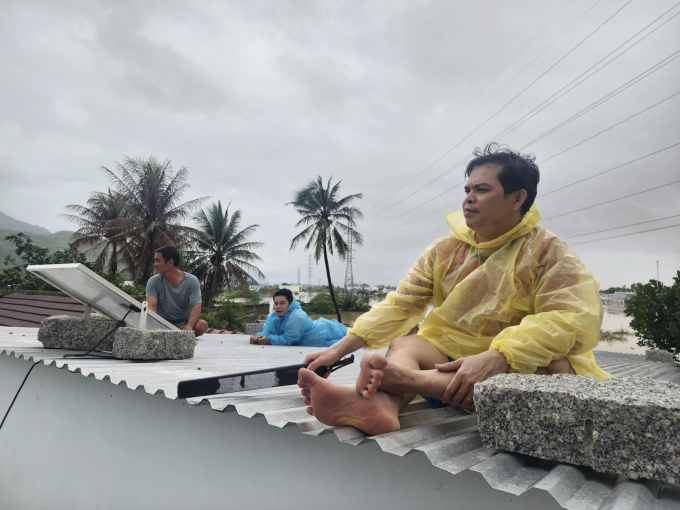 Người dân phường Nam Nha Trang ngồi trên mái nhà chờ cứu hộ, sáng 20/11. Ảnh: Bảo Hòa