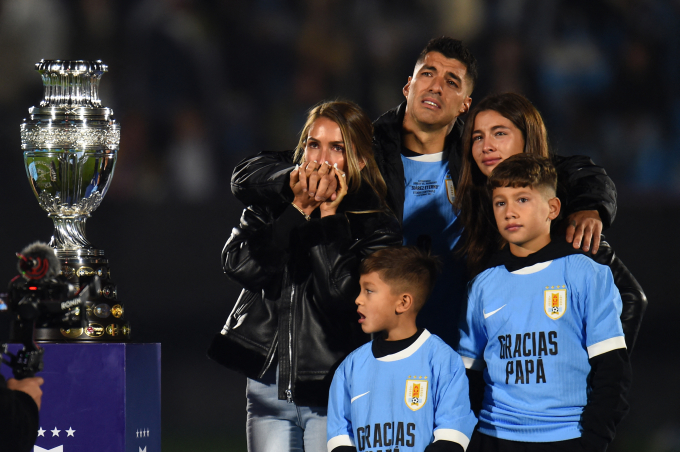 Suarez khóc khi đứng cạnh vợ Sofia Balbi (trái) và các con Delfina (phải), Lautaro (giữa), và Benjamin bên bản sao cup vô địch Copa America trong buổi lễ tri ân anh ở trận đấu cuối cùng cho tuyển Uruguay trên sân Centenario, Montevideo ngày 6/9/2024. Ảnh: AFP
