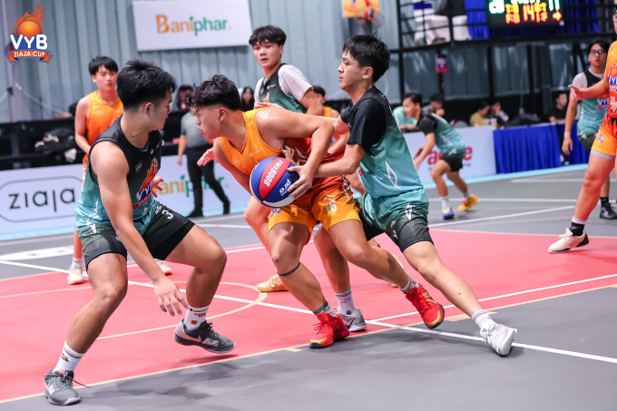 Cầu thủ đội THPT Marie Curie (áo vàng) che bóng trước sự áp sát của THPT Nguyễn Tất Thành. Ảnh: VYB