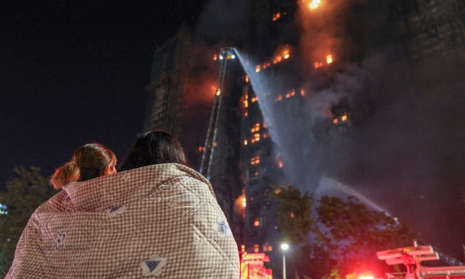 Cư dân đứng nhìn đám cháy tại các tòa chung cư thuộc khu Wang Fuk Court, Hong Kong, tối 26/11. Ảnh: Reuters