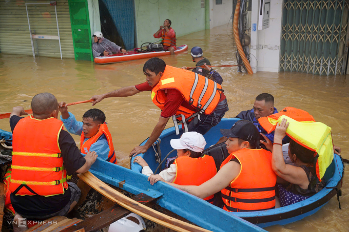 Lực lượng chức năng hỗ trợ người dân qua điểm ngập lụt ở phường Tây Nha Trang, ngày 20/11. Ảnh: Bùi Toàn