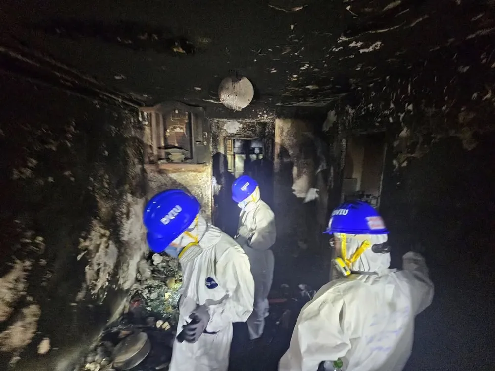 Các chuyên gia DVIU tìm kiếm nạn nhân bên trong các toà nhà bị hoả hoạn ở Wang Fuk Court. Ảnh: AFP/Hong Kong Police Office 0112 Những hình ảnh đầu tiên trong khu chung cư bị hoả hoạn thiêu trụi ở Hong Kong_13.jpg