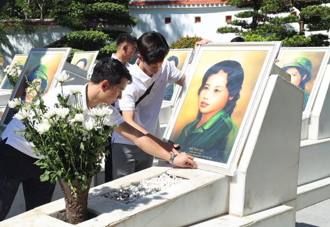 Các thành viên nhóm đặt chân dung và thắp hương trên mộ liệt sĩ Hồ Thị Cúc tại Khu di tích Ngã ba Đồng Lộc, Hà Tĩnh năm 2022. Ảnh: Skyline