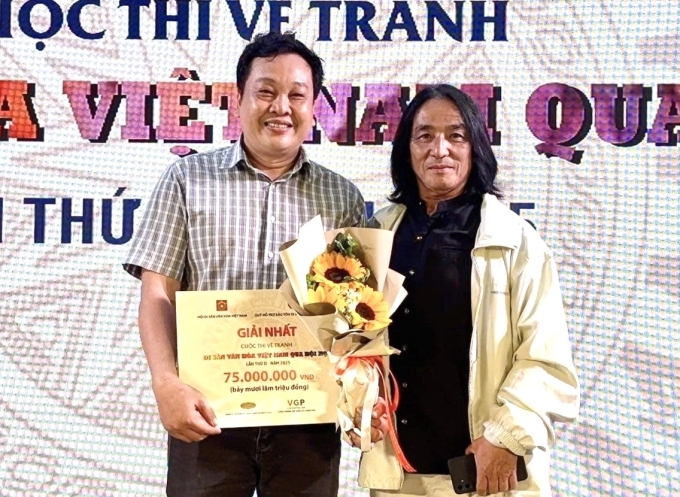 Thạc sĩ Lê Phi Hùng (trái) ở lễ trao giải. Anh 47 tuổi, hiện là Phó trưởng khoa Mỹ thuật tạo hình, ngành Đồ họa, trường Đại học Mỹ thuật TP.HCM. Ảnh: Nhân vật