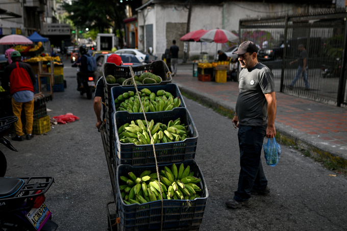 Một người kéo xe chất đầy chuối ở Caracas, Venezuela ngày 13/11. Ảnh: AFP