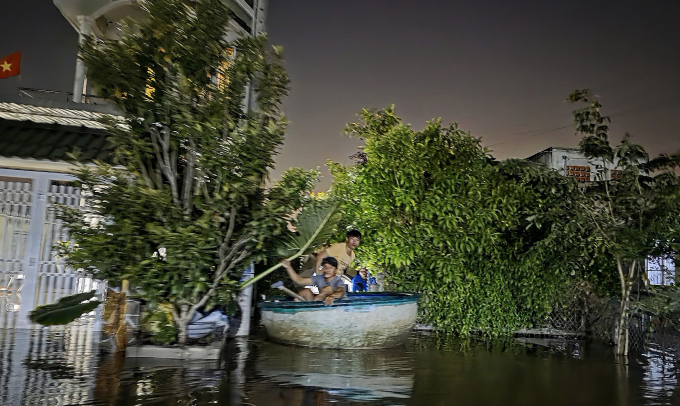 Người dân bơi xuồng để thoát khỏi chỗ ngập. Ảnh: Phước Tuấn