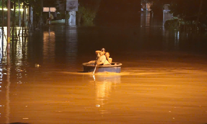 Người dân ở ven sông Phú Hài chèo thuyền thúng để thoát khỏi nhà ngập ra ngoài. Ảnh: Việt Quốc