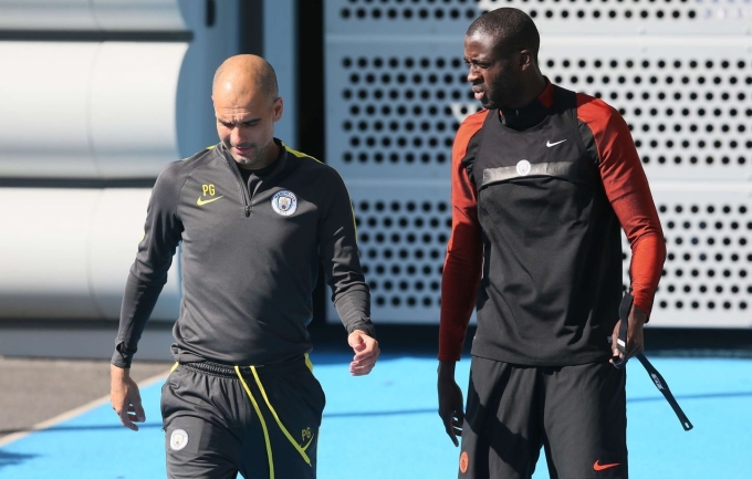 Toure đi theo Guardiola trong một buổi tập của Man City. Ảnh: Reuters