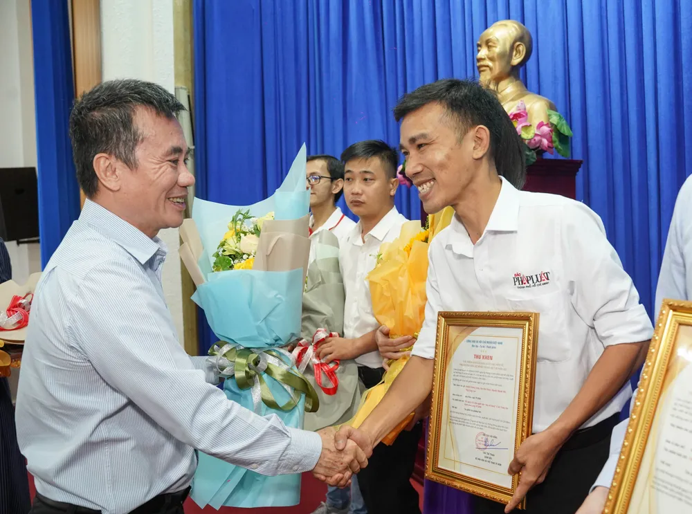 Ông Dương Vũ Thông, Phó Chủ tịch Thường trực Hội Nhà báo TP.HCM, trao hoa chúc mừng nhóm tác giả. Ảnh: THUẬN VĂN khen-thuong-70-tac-pham-5.jpg