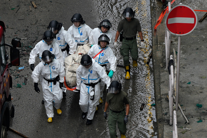 Lực lượng cứu hộ đưa túi đựng xác khỏi hiện trường đám cháy ở cụm chung cư Wang Fuk Court, Hong Kong, ngày 30/11. Ảnh: AP