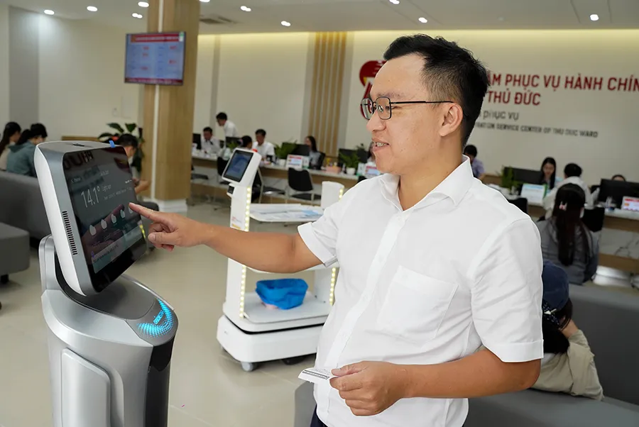 Robot lễ tân tại Trung tâm hành chính công phường Thủ Đức (TP.HCM) giao tiếp bằng giọng nói, tương tác trực tiếp với người dân. Ảnh: THUẬN VĂN p4-5anhphu.jpg