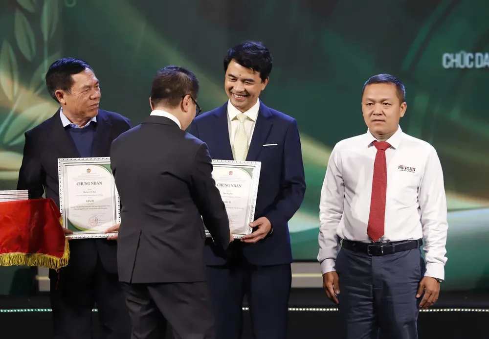 Ông Võ Thanh Tùng (ngoài cùng bên phải) đại diện nhóm tác giả loạt bài "Tiếng kêu ai oán giữa rừng xanh" nhận giấy chứng nhận của Ban Tổ chức. Giải B 1.jpg