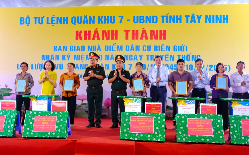 Thượng tướng Võ Minh Lương, Ủy viên Thường vụ Quân ủy Trung ương và Thiếu tướng Trần Vinh Ngọc, Bí thư Đảng ủy, Chính ủy Quân khu 7 cùng ông Lê Văn Hẳn, Chủ tịch UBND tỉnh Tây Ninh bàn giao nhà và tặng quà cho các hộ gia đình ở điểm dân cư biên giới. Ảnh: HD chương trình về nguồn 5.jpg