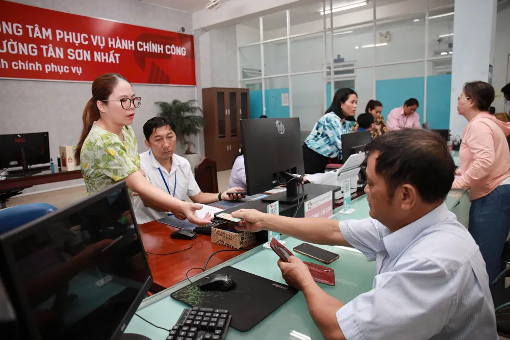 Cán bộ nhiệt tình hỗ trợ người dân. Ảnh: NGUYỆT NHI bo-may-thi-dua-100-ngay-2.jpg