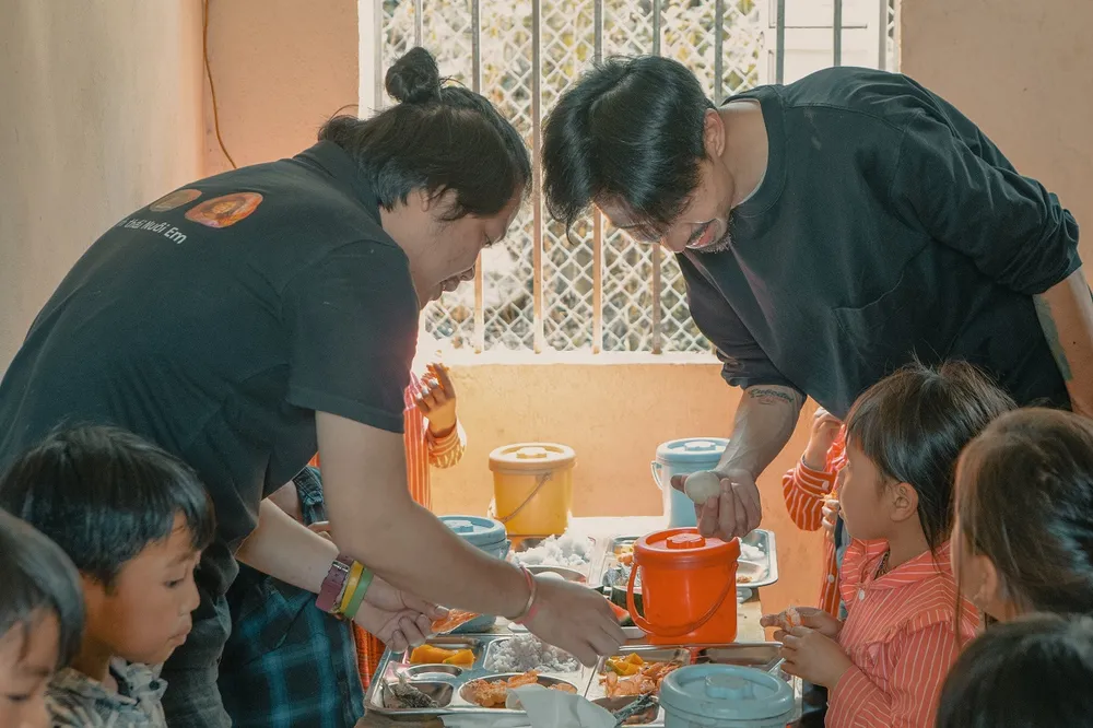 Đen và Hoàng Hoa Trung trong một chuyến đi lên vùng cao thăm các em nhỏ. Ảnh: VTV den-vau-len-tieng-truoc-nghi-van-minh-bach-tai-chinh-cua-du-an-nuoi-em.jpg