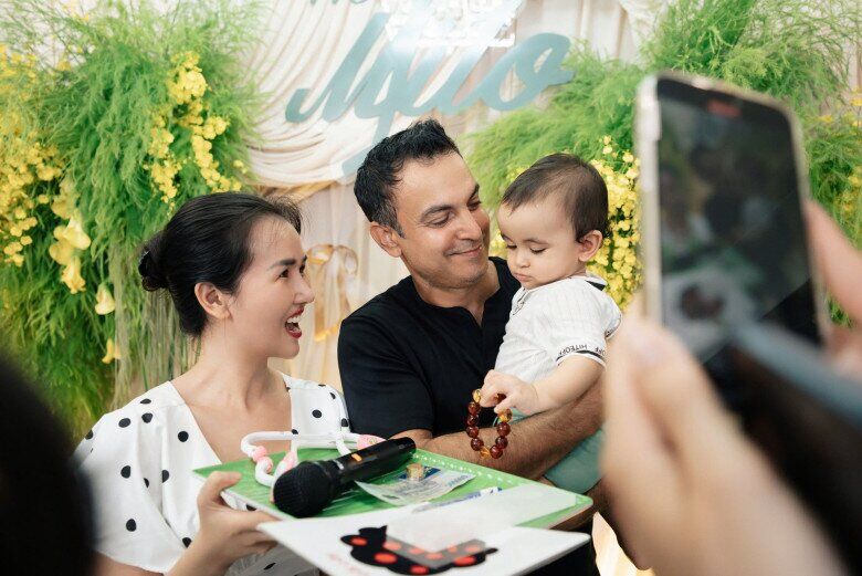 Con trai Võ Hạ Trâm bốc tràng hạt của ông ngoại trong lễ thôi nôi.