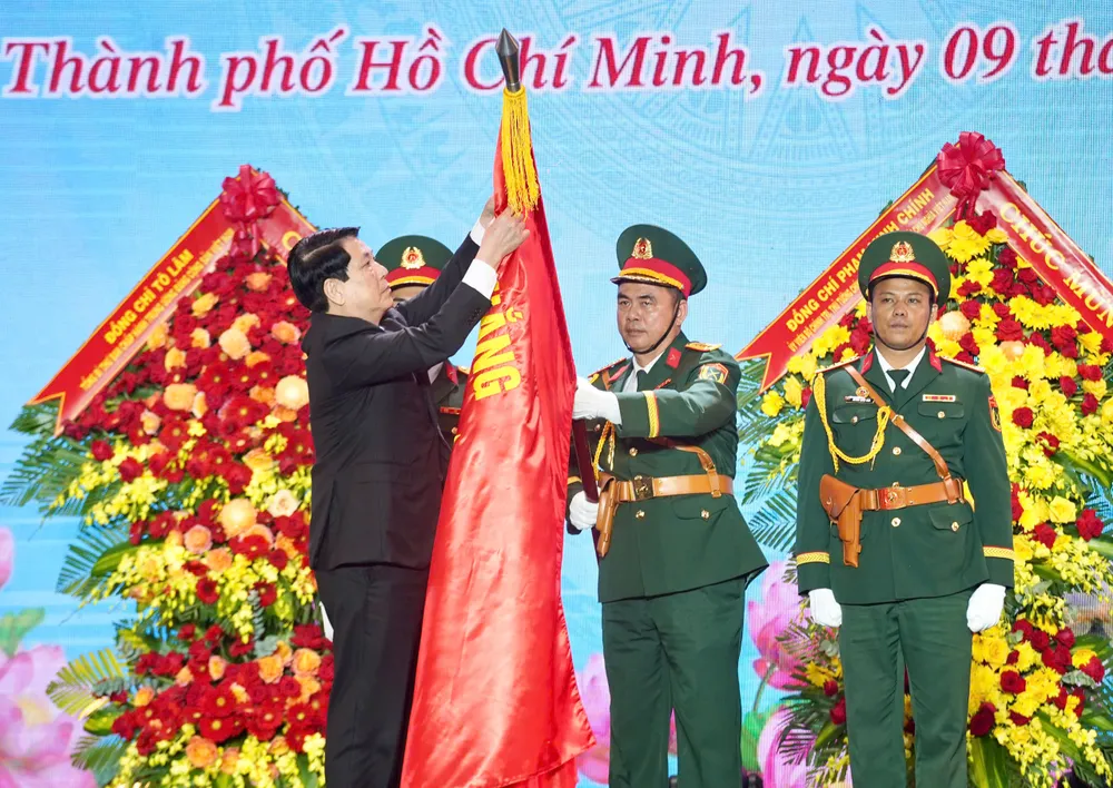 Chủ tịch nước Lương Cường gắn huy hiệu Anh hùng LLVT nhân dân lên Quân kỳ Quyết thắng cho Quân khu 7. Ảnh: THUẬN VĂN Chủ tịch nước trao danh hiệu Anh hùng Lực lượng vũ trang Nhân dân cho Quân khu 7 -quan-khu-7-80-nam (2).jpg