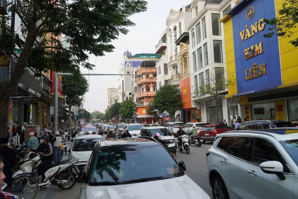 Trên tuyến phố Lê Hoàn, nhiều người dân hiếu kỳ theo dõi quá trình khám xét của lực lượng chức năng, khiến cho các phương tiện lưu thông gặp khó khăn. Ảnh: ĐẶNG TRUNG Toàn cảnh khám xét, bắt giam vợ chồng chủ tiệm vàng nổi tiếng ở Thanh Hóa - 8.jpg