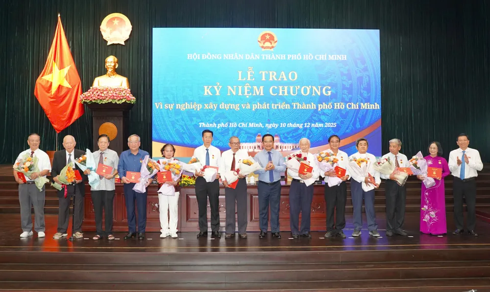 Chủ tịch UBND TP.HCM Nguyễn Văn Được và Phó Chủ tịch HĐND TP.HCM Trần Văn Tuấn tặng Kỷ niệm chương cho các cá nhân. Ảnh: THUẬN VĂN nghi-quyet-hdnd-tp.hcm-2.jpg