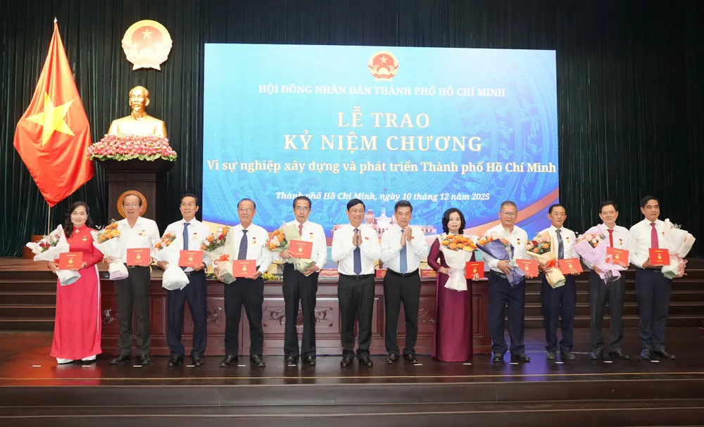 Chủ tịch HĐND TP.HCM Võ Văn Minh và Phó Chủ tịch UBND TP.HCM Nguyễn Văn Dũng tặng Kỷ niệm chương cho các cá nhân. Ảnh: THUẬN VĂN nghi-quyet-hdnd-tp.hcm-5.jpg