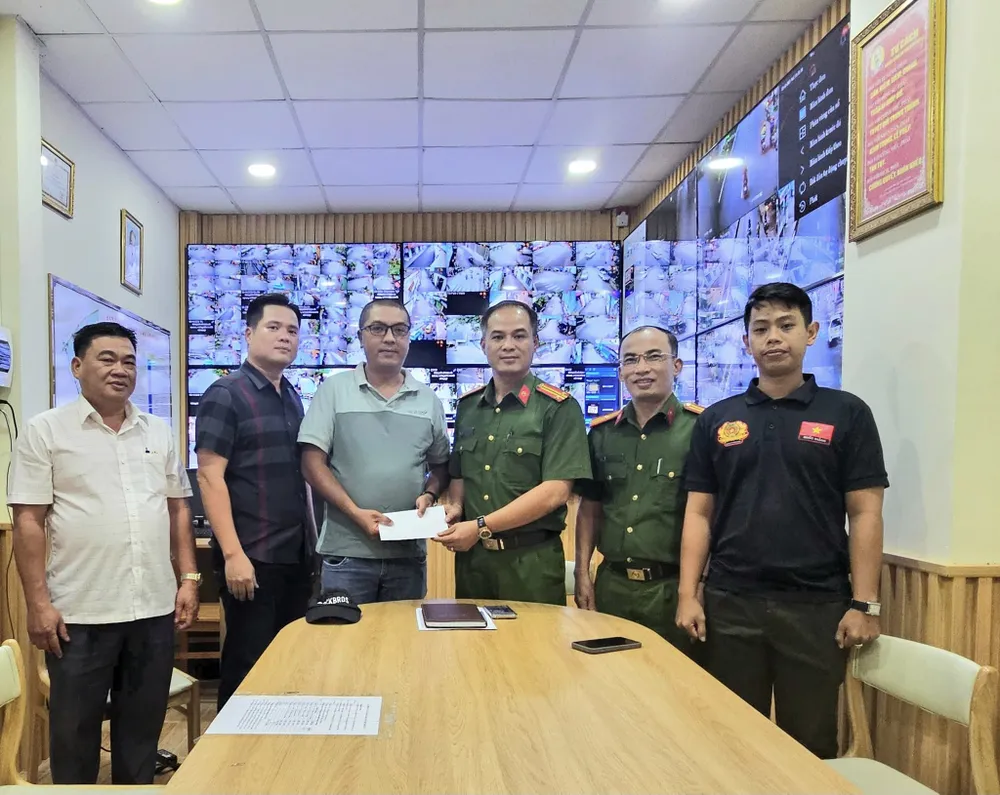 Trung tá Nguyễn Quốc Tuấn, Trưởng Công an phường trao tặng quà cho anh Lân. Ảnh: CA tp-hcm-cong-an-phuong-hu-coi-mo-duong-dua-thai-phu-den-benh-vien-00.jpg