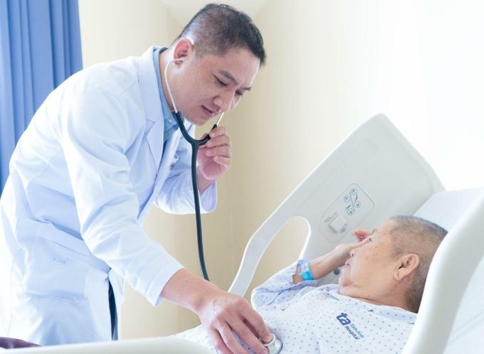 Bác sĩ Vinh kiểm tra sức khỏe bà Hoa trước khi xuất viện. Ảnh: Ngọc Châu