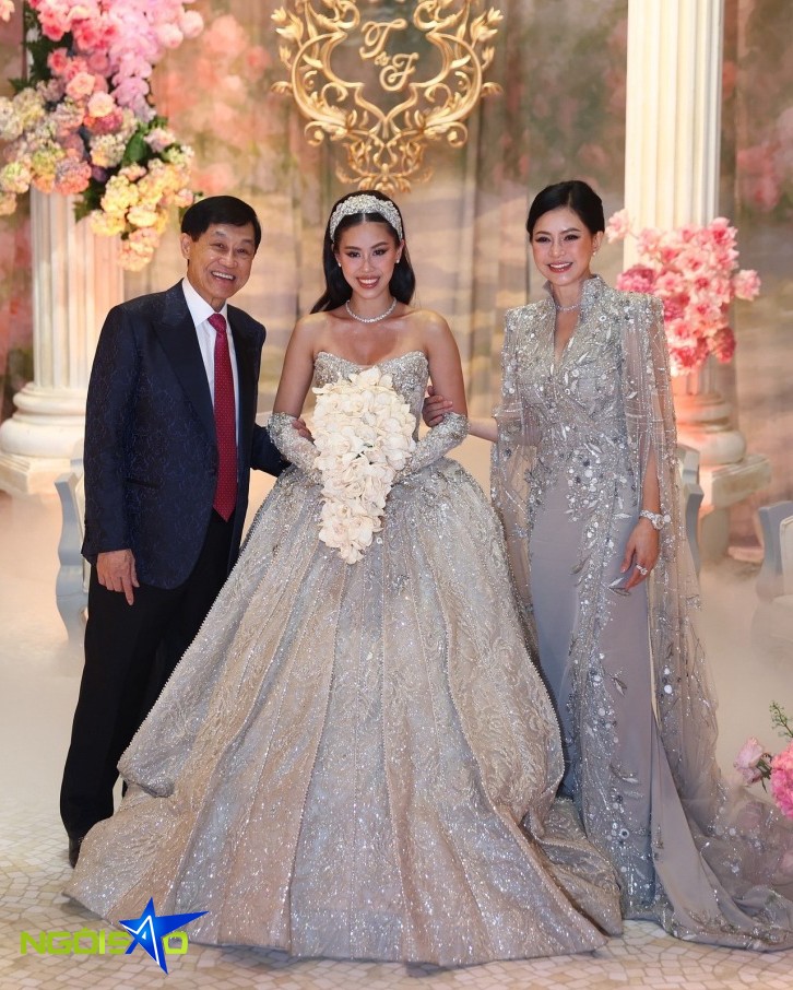 Đồ đôi vương giả của phu nhân và ái nữ nhà vua hàng hiệu 3 Tối cùng ngày, mẹ con Tiên Nguyễn tiếp tục chưng diện đồ đồng điệu. Cô dâu mặc bộ đầm Jimmy Choo đính kết hàng nghìn viên đá quý, ước tính trị giá trên một tỷ đồng. Trong khi phu nhân của Johnathan Hạnh Nguyễn diện đồ Haute Couture của Ziad Nakad được chỉnh sửa riêng, giá khoảng hơn 600 triệu đồng.