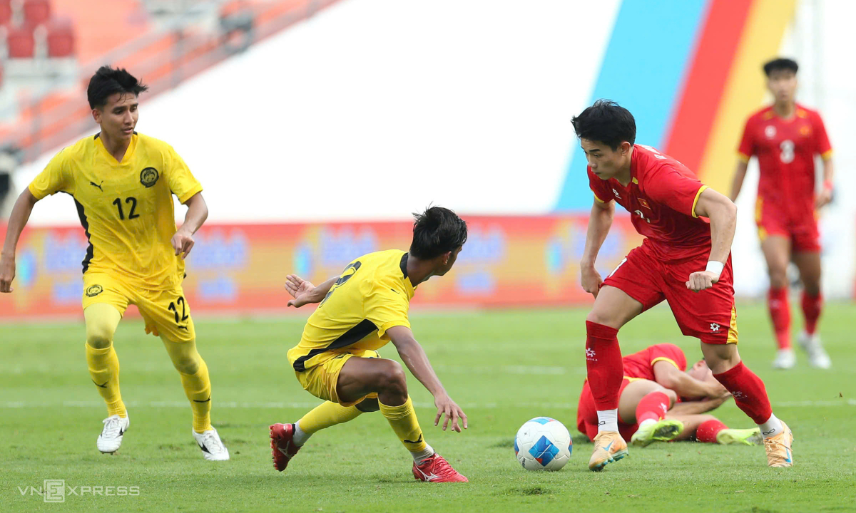 Đình Bắc rê bóng qua cầu thủ Malaysia. Ảnh: Hiếu Lương